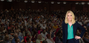 Kim Jones, executive career coach, standing in front of crowded conference audience